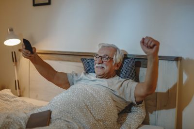 resized happy mature man cheering while watching sports match tv bedroom